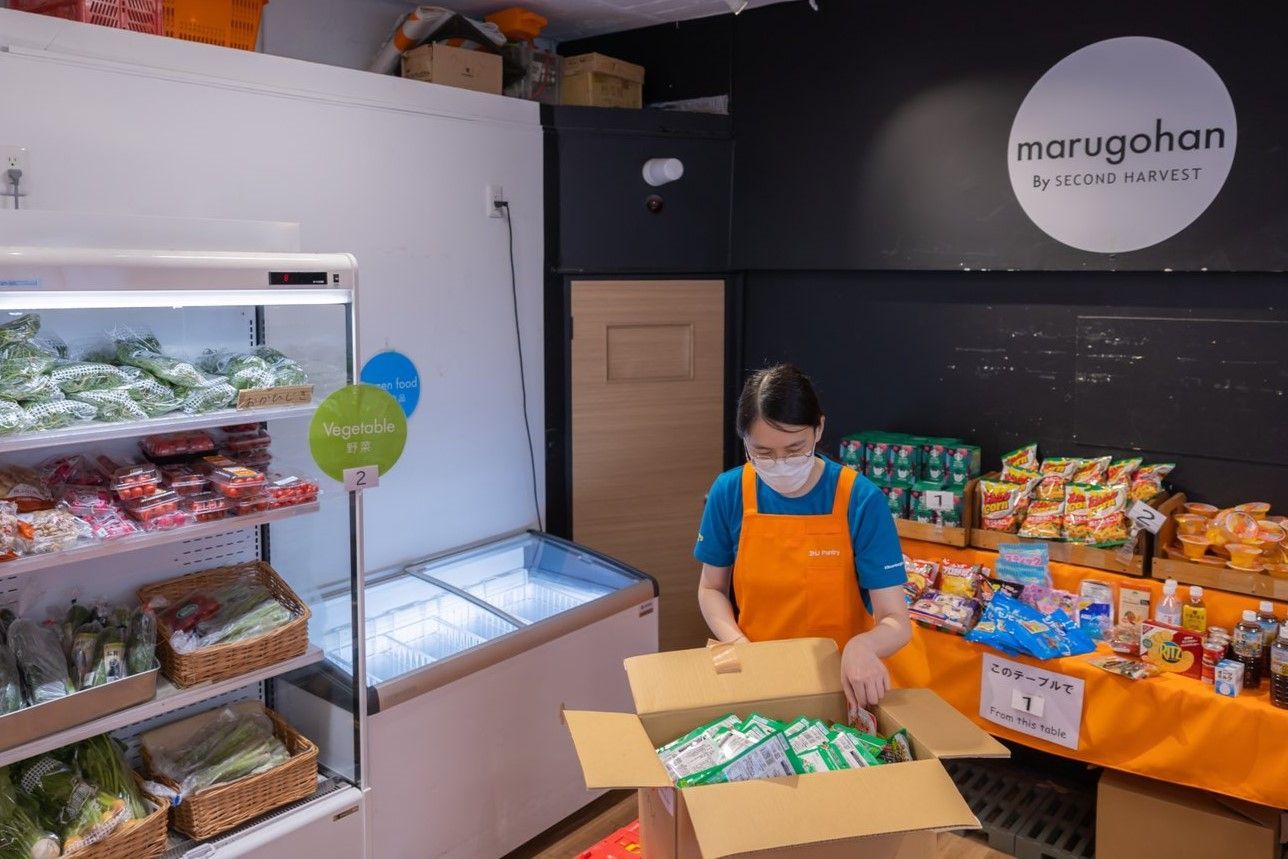 運ばれてきた食料品を補充するスタッフ